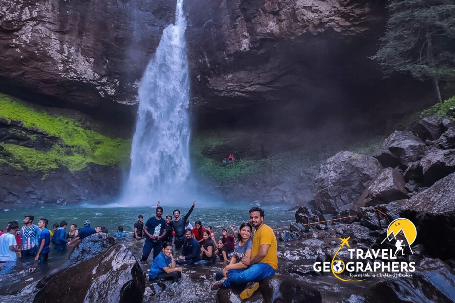 Group enjoying near waterfall in rocky landscape.