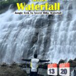 Person enjoying waterfall in forest