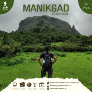 Hiker viewing Manikgad mountain lush landscape.