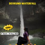 Woman sitting by Devkund Waterfall, tour info displayed.