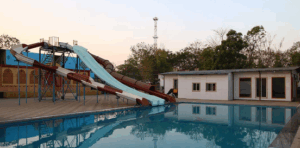 Water slides beside a recreational pool at sunset.