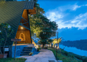 Cozy A-frame cabin by the river at sunset.