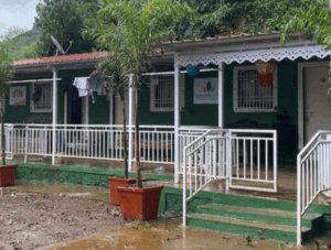 Green building with porch and white railings