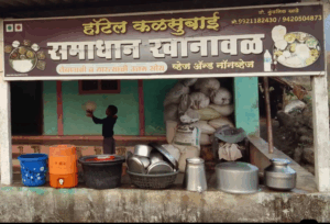 Boy balancing a ball outside a food shop.