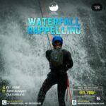 Person rappelling down a waterfall, adventure event.