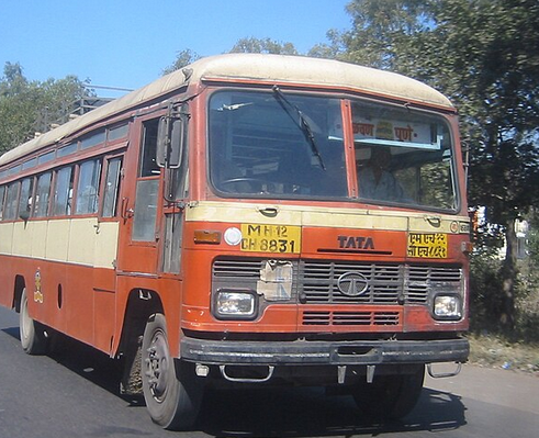 Red and beige Tata bus on road