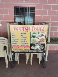 Restaurant menu board with various Indian dishes.