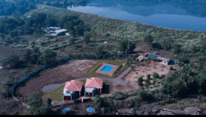 Aerial view of house, pool, and surrounding landscape.