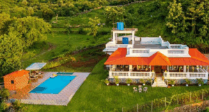 Villa with pool in lush, green landscape.