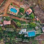 Aerial view resort layout with villas and swimming pools.