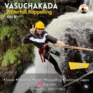 Woman rappelling down Vasuchakada waterfall, smiling.