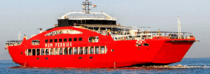 Red ferry boat sailing on calm ocean waters.