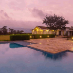 Serene villa with pool at sunset.