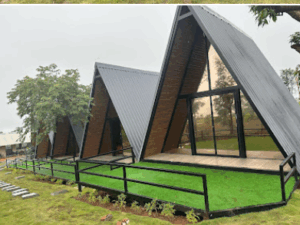 Modern A-frame cabins with glass fronts and greenery.