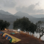 Colorful tents by a lakeside at dusk.